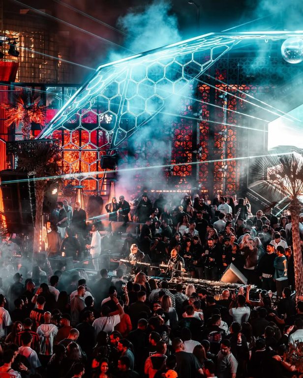 Guests beneath the angular HIVE DXB lighting canopy during an earlier night