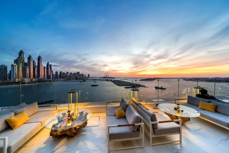 A rooftop lounge at sunset with the Dubai Marina skyline